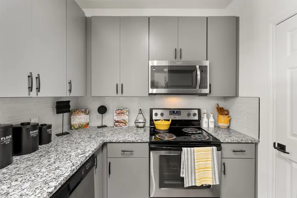 a kitchen with stainless steel appliances granite countertop a sink stove and microwave