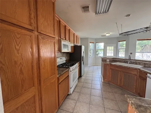 a large kitchen with stainless steel appliances granite countertop a stove and a sink