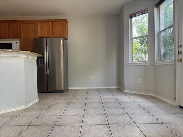 a view of a kitchen with refrigerator and window
