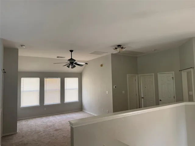a view of a livingroom with a ceiling fan and window