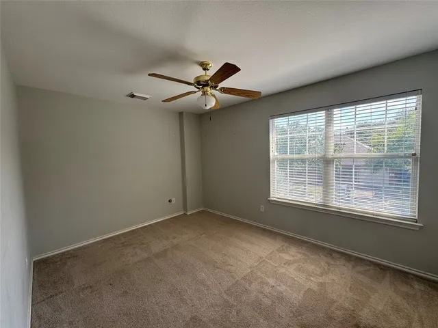 an empty room with a window and a fan