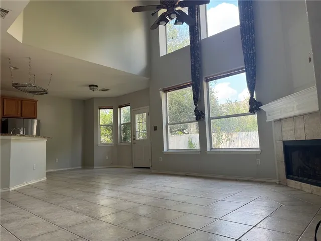 an empty room with windows and fireplace