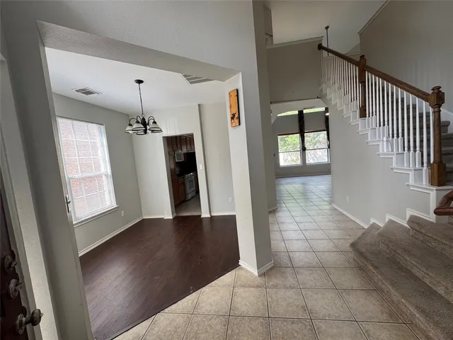 a view of a hallway with wooden floor and staircase