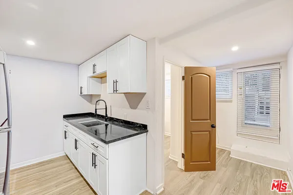 a kitchen with granite countertop a sink stove and refrigerator