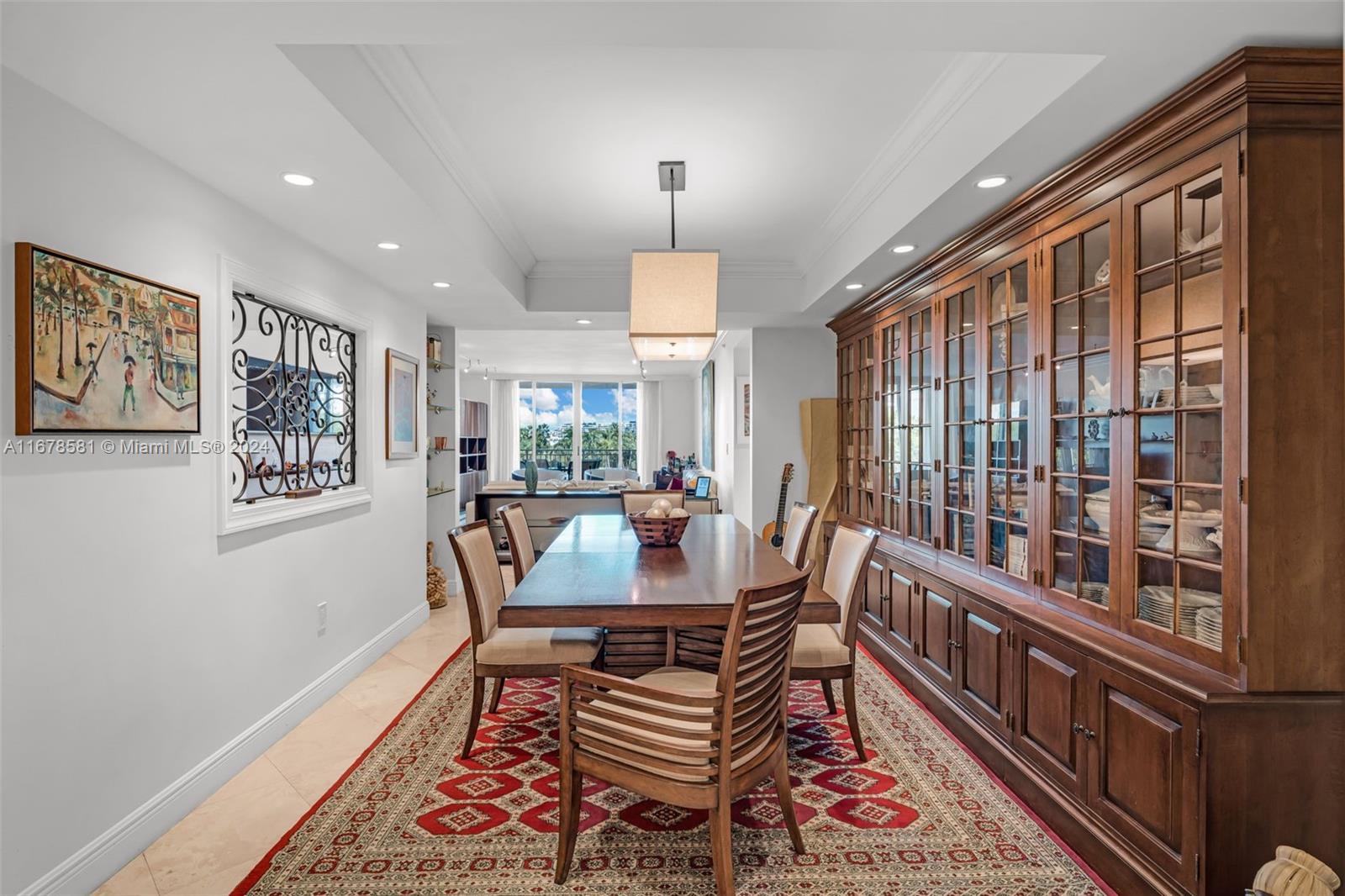 765 Crandon Boulevard, Unit 305 Key Biscayne, FL 33149 - Photo 12 of 55 a dining room with furniture a rug and a chandelier