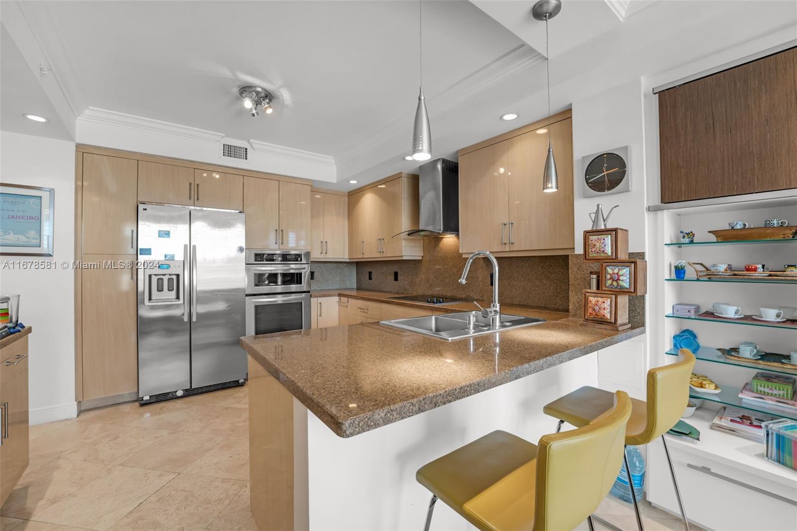 765 Crandon Boulevard, Unit 305 Key Biscayne, FL 33149 - Photo 16 of 55 a kitchen with stainless steel appliances granite countertop a sink refrigerator and cabinets
