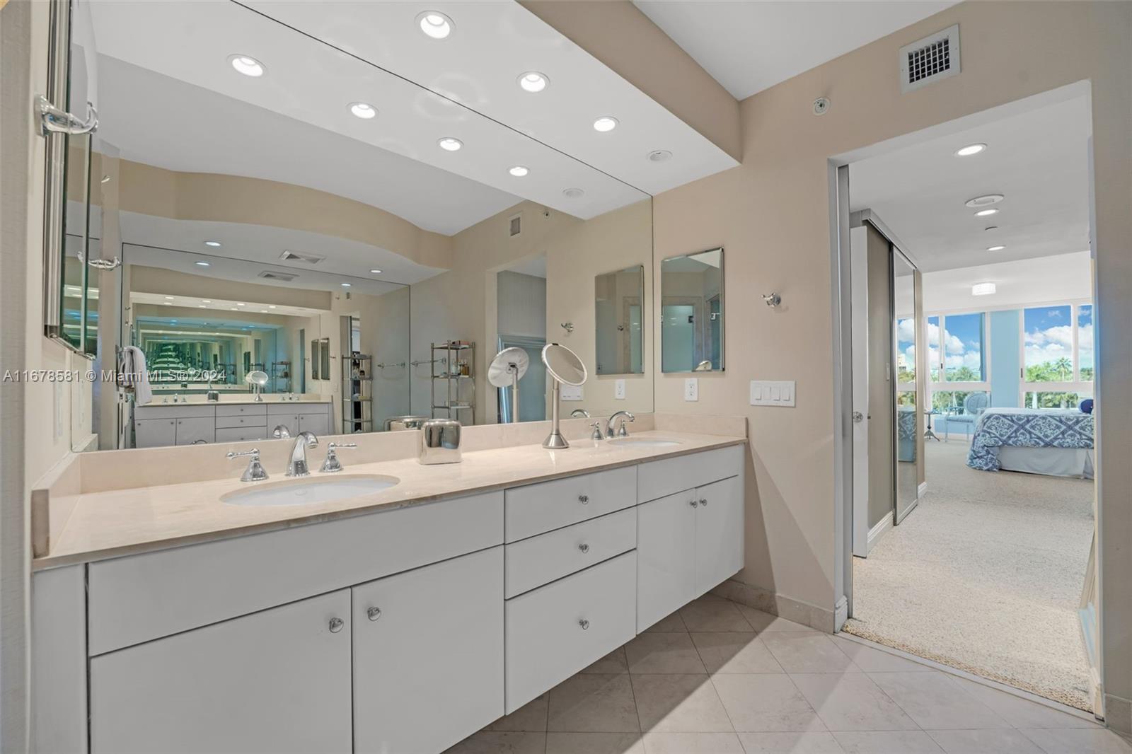 765 Crandon Boulevard, Unit 305 Key Biscayne, FL 33149 - Photo 24 of 55 a en suite bathroom with a double vanity sink a large mirror and shower