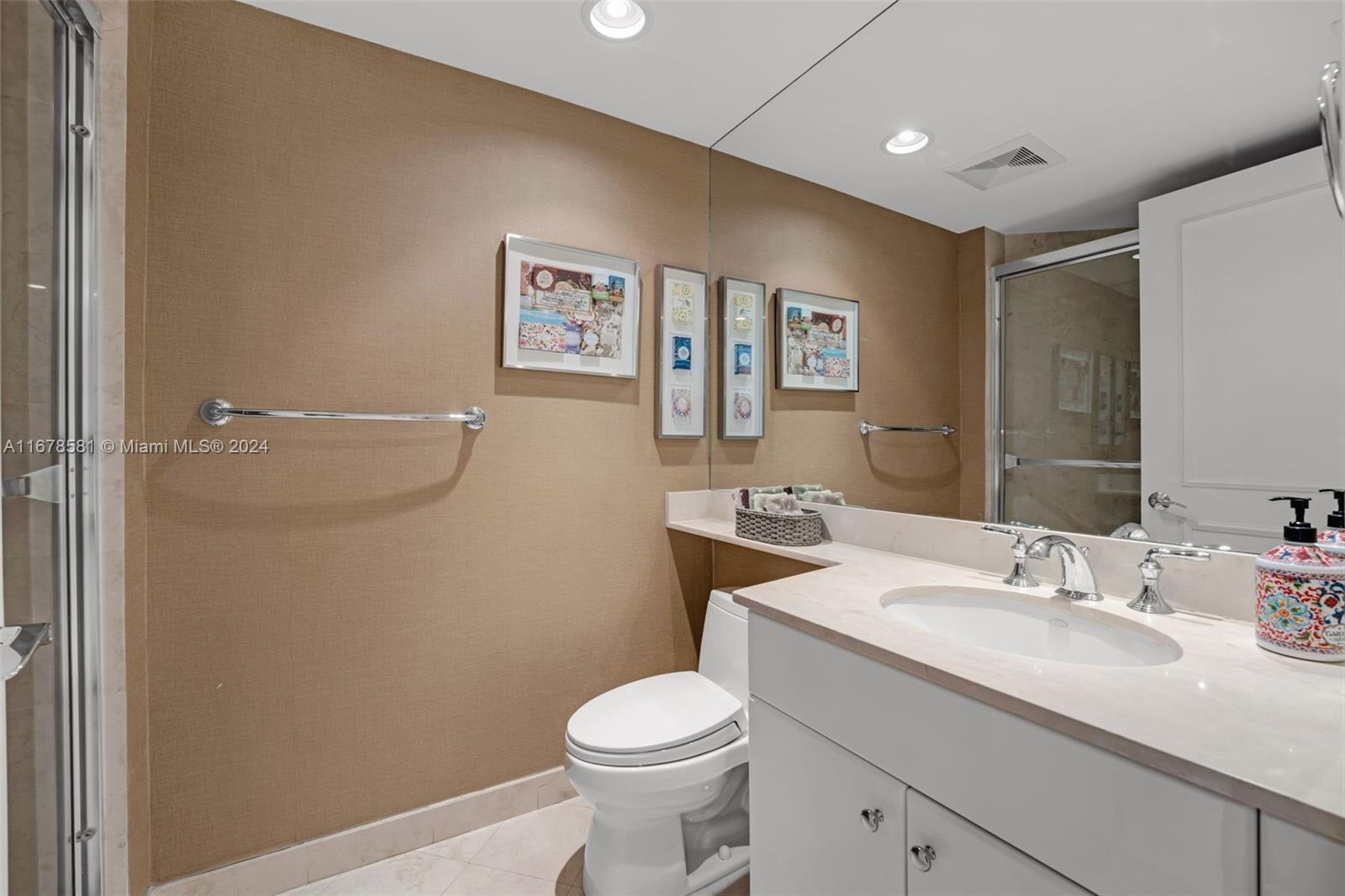 765 Crandon Boulevard, Unit 305 Key Biscayne, FL 33149 - Photo 36 of 55 a bathroom with a toilet sink and mirror