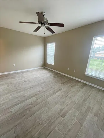 an empty room with a window and a ceiling fan