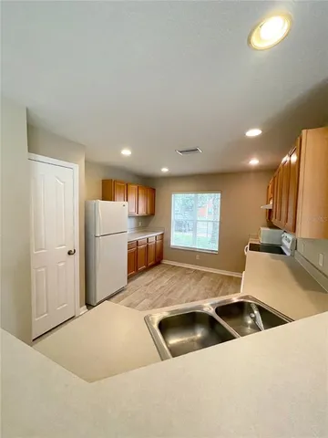 a kitchen with stainless steel appliances granite countertop a sink and a refrigerator
