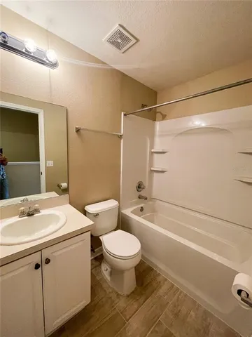 a bathroom with a sink a toilet a mirror and shower