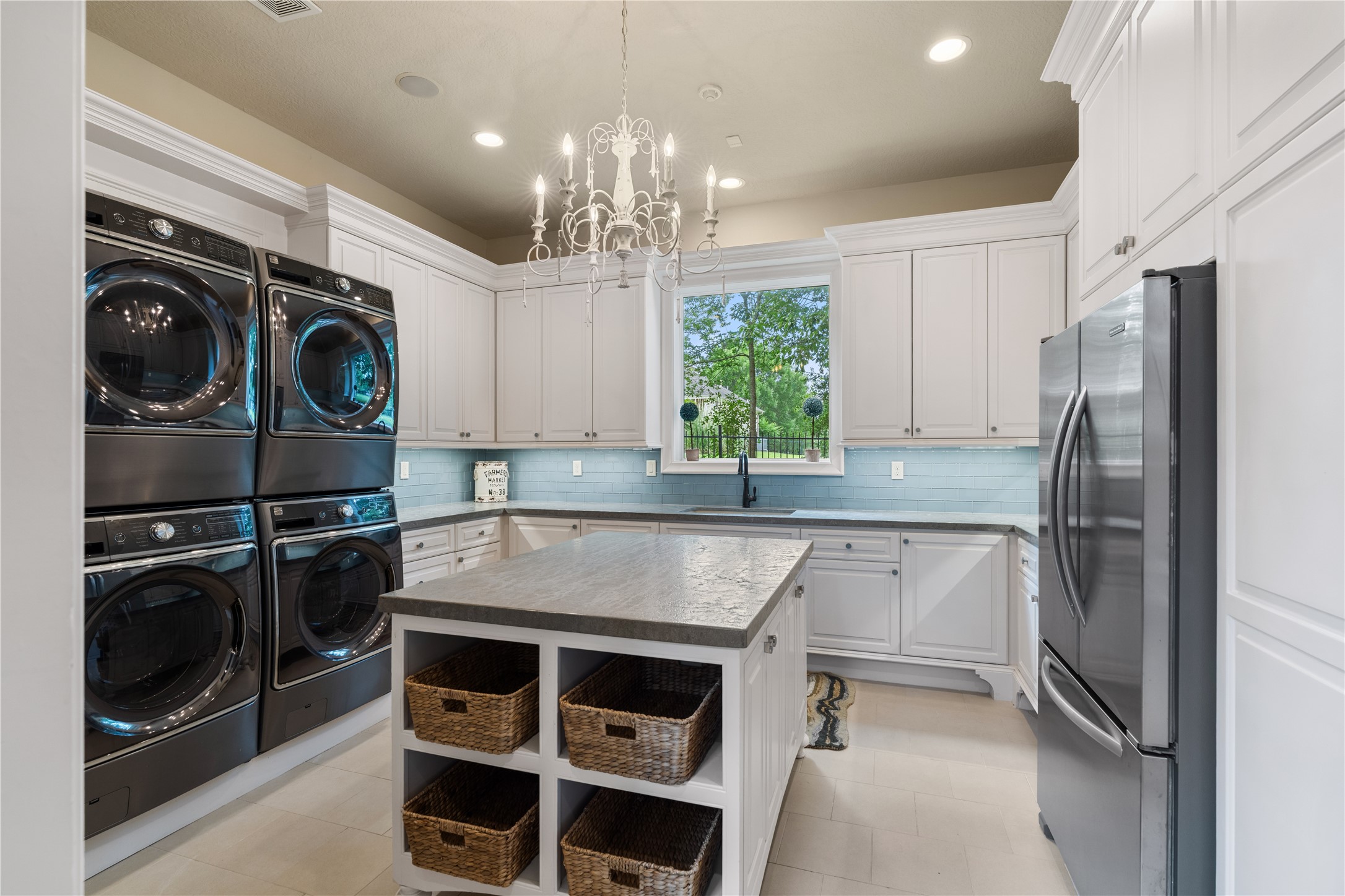 12349 Longmire Trace Conroe, TX 77304 - Photo 20 of 48 Designer utility room with custom cabinetry, oversized island, and sunlit window for effortless organization.