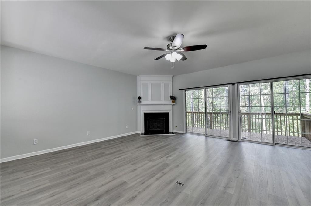 3977 Howell Park Road Duluth, GA 30096 - Photo 8 of 25 a view of empty room with wooden floor and fireplace