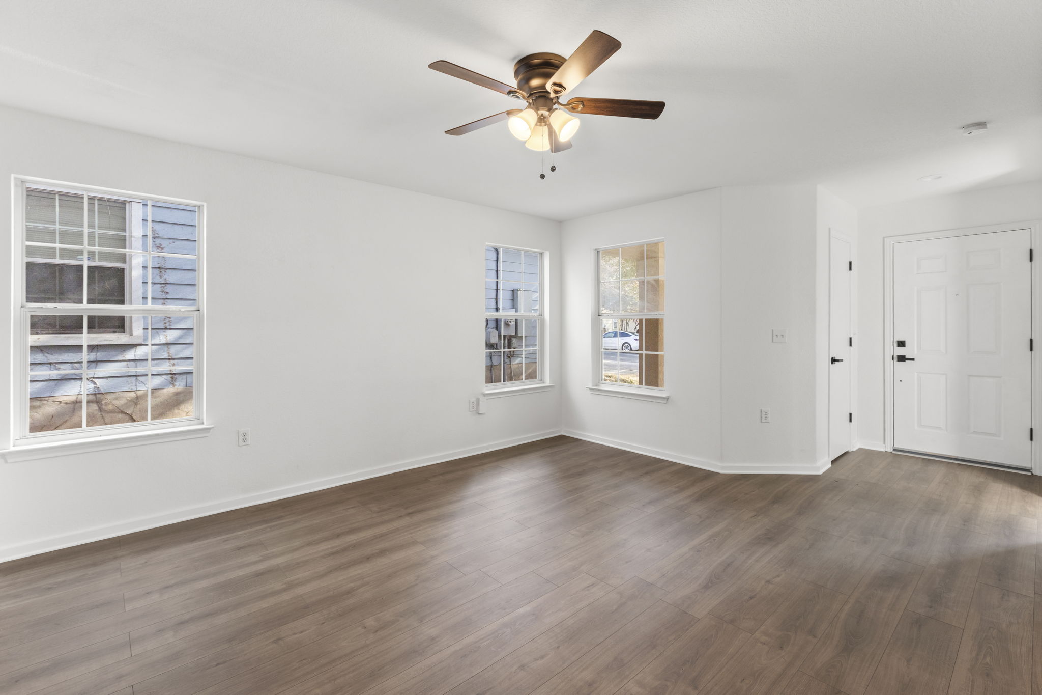 2110 Nogales Trail Austin, TX 78744 - Photo 9 of 37 a view of an empty room with a window and wooden floor