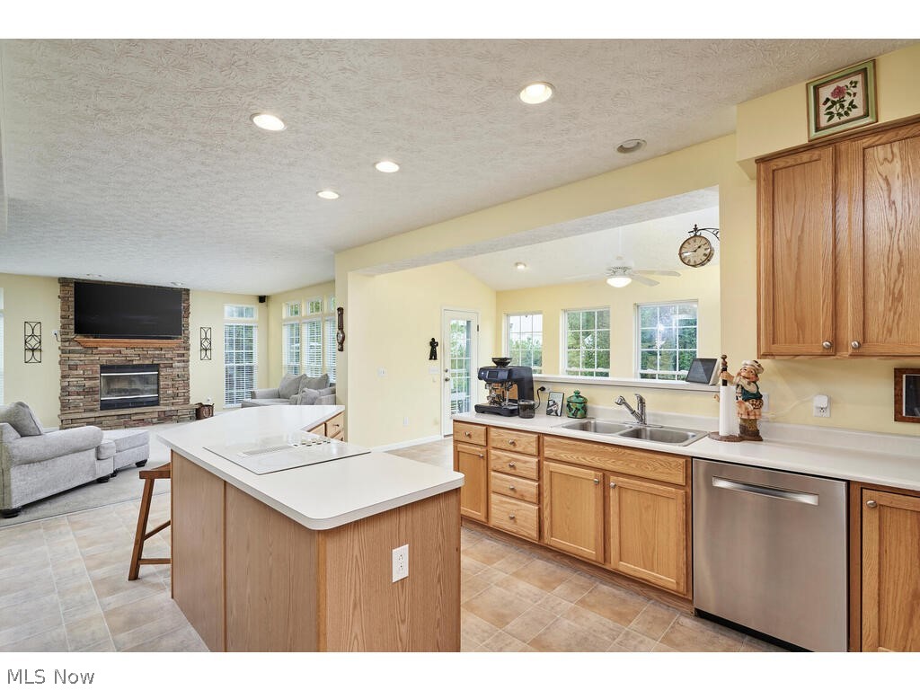 5172 Shillings Way Akron, OH 44321 - Photo 7 of 26 Kitchen with light tile flooring, a fireplace, sink, dishwasher, and a textured ceiling