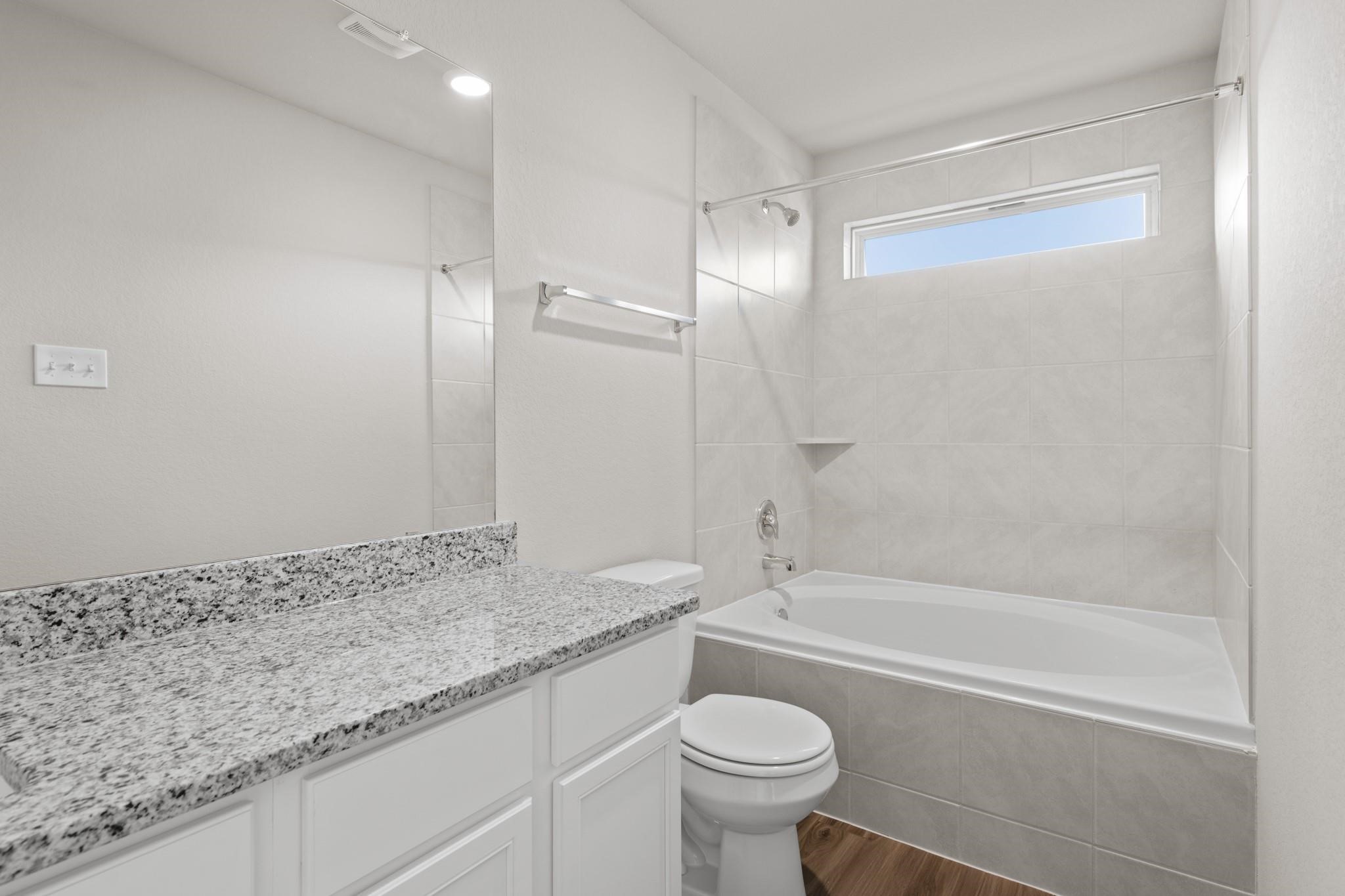 506 Moose Run Huntsville, TX 77320 - Photo 12 of 26 a bathroom with a granite countertop sink a toilet and bathtub