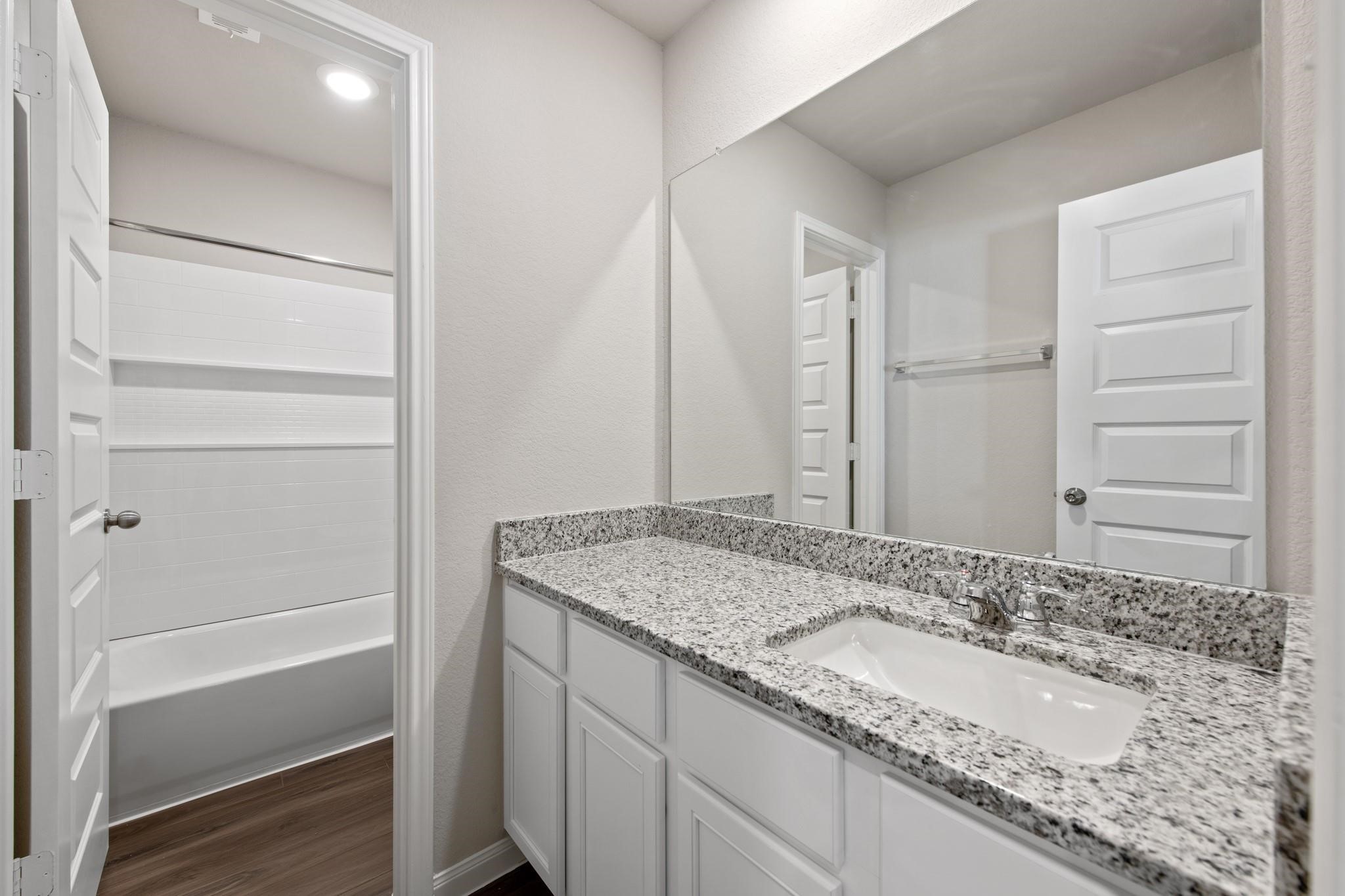 506 Moose Run Huntsville, TX 77320 - Photo 17 of 26 a bathroom with a granite countertop sink and a mirror