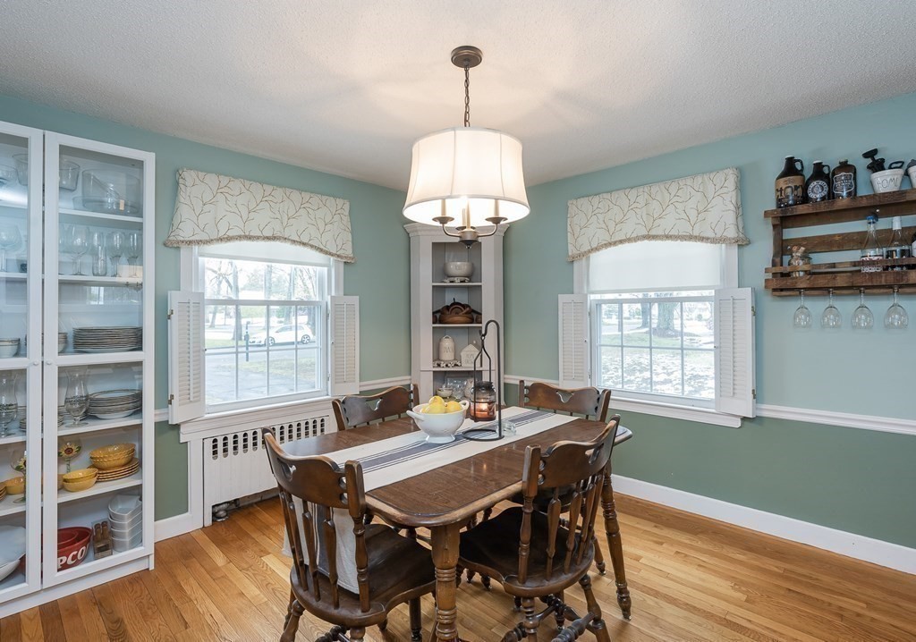 97 Bridle Path Road Springfield, MA 01118 - Photo 11 of 42 a dining room with wooden floor a chandelier a wooden table and chairs