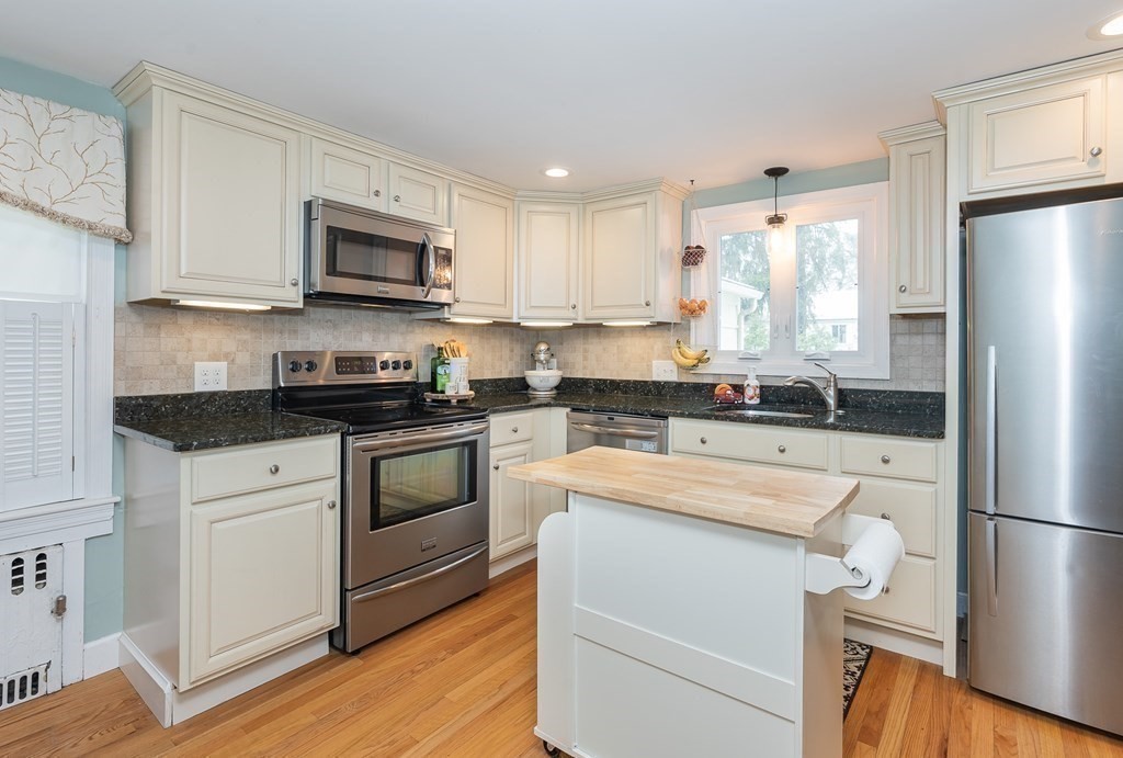 97 Bridle Path Road Springfield, MA 01118 - Photo 14 of 42 a kitchen with white cabinets and stainless steel appliances