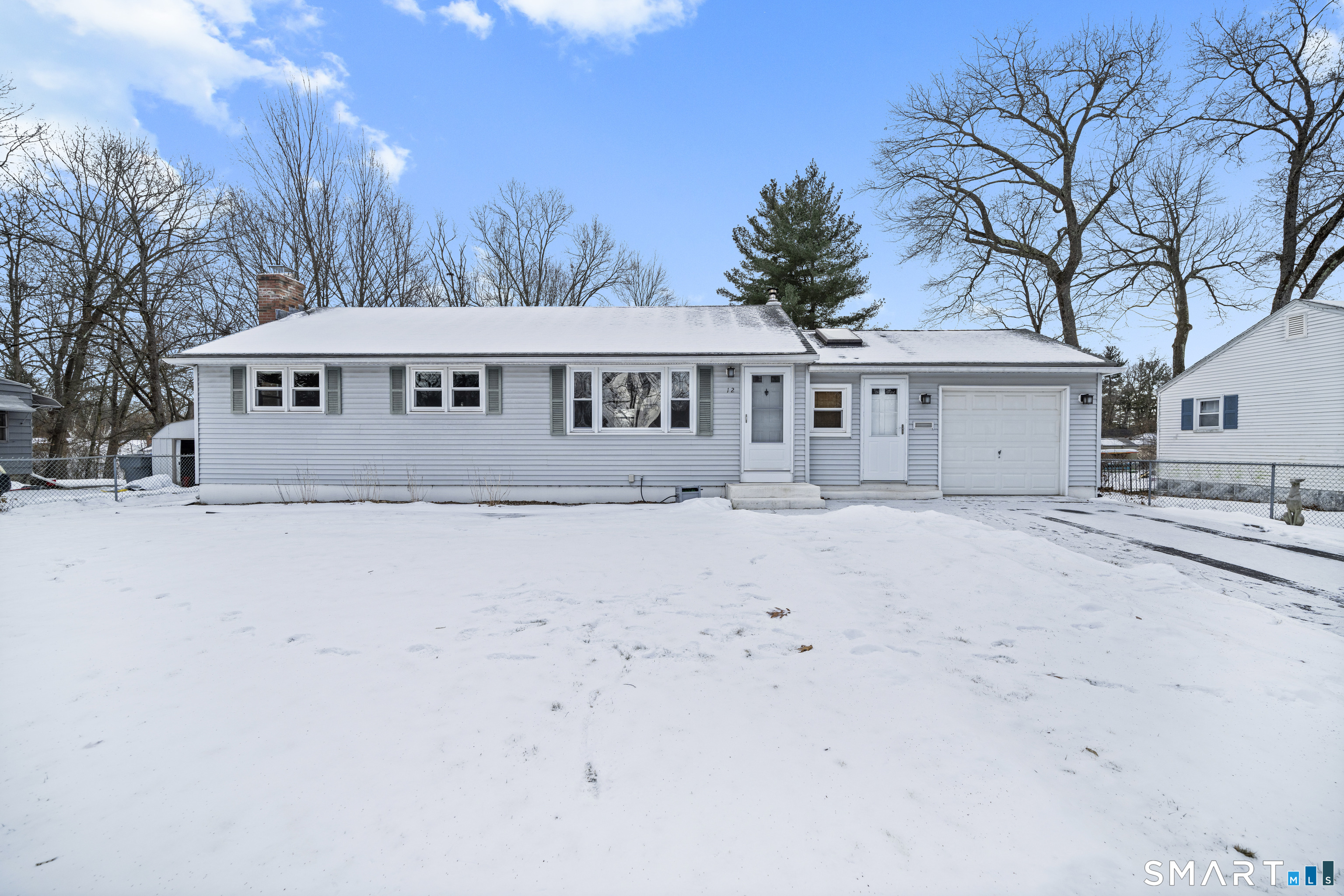 a front view of a house with a yard covered in snow