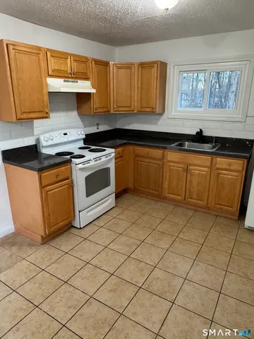 a kitchen with granite countertop a sink cabinets and window