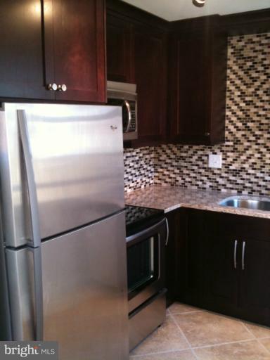 3903 Weller Road Silver Spring, MD 20906 - Photo 14 of 18 a kitchen with granite countertop stainless steel appliances and wooden cabinets