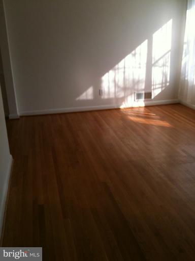 3903 Weller Road Silver Spring, MD 20906 - Photo 4 of 18 a view of an empty room with wooden floor and a window
