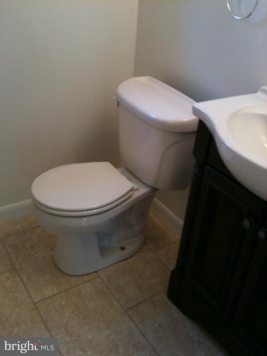 3903 Weller Road Silver Spring, MD 20906 - Photo 8 of 18 a white toilet sitting next to a white sink and vanity