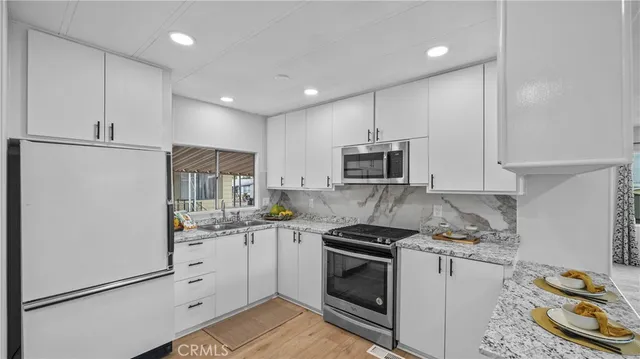 a kitchen with white cabinets and appliances