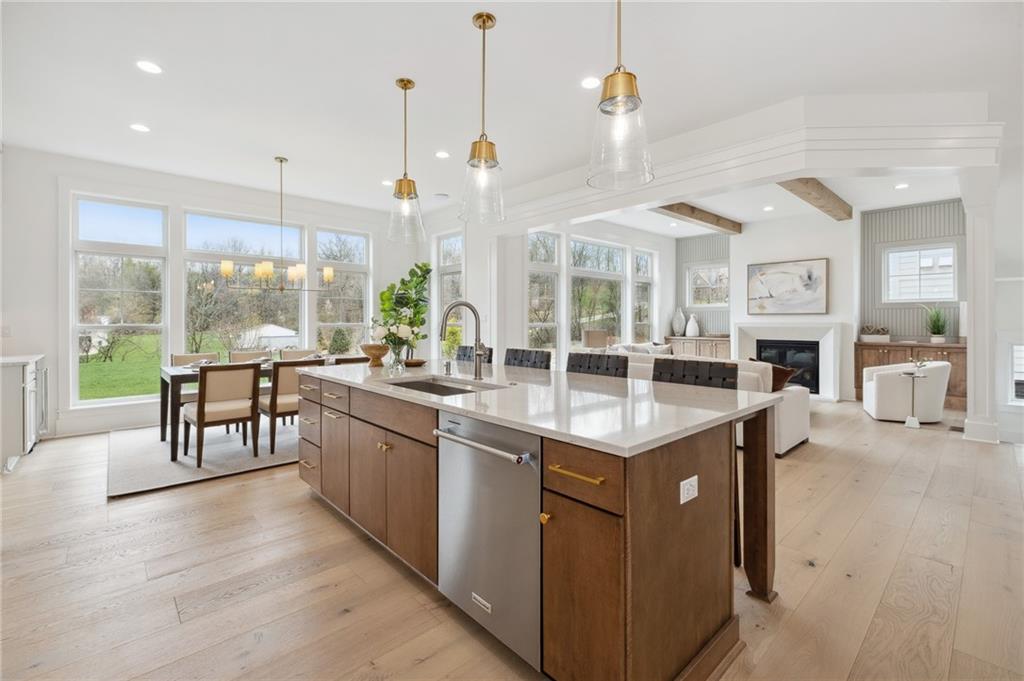 205 Rothaar Court Venetia, PA 15367 - Photo 11 of 35 a open kitchen with granite countertop a stove a sink a dining table and chairs with wooden floor