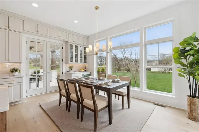 a dining room with furniture a chandelier and wooden floor