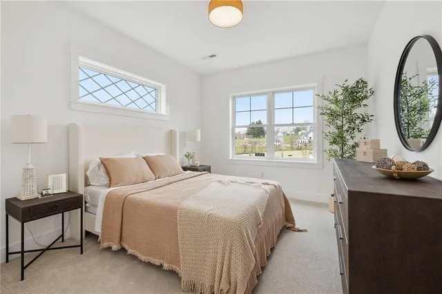 a bedroom with a bed a mirror and a large window