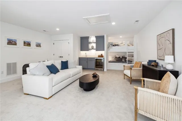 a living room with furniture and a view of kitchen