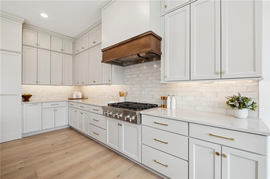 205 Rothaar Court Venetia, PA 15367 - Photo 10 of 35 a kitchen with granite countertop a stove a sink dishwasher and white cabinets with wooden floor