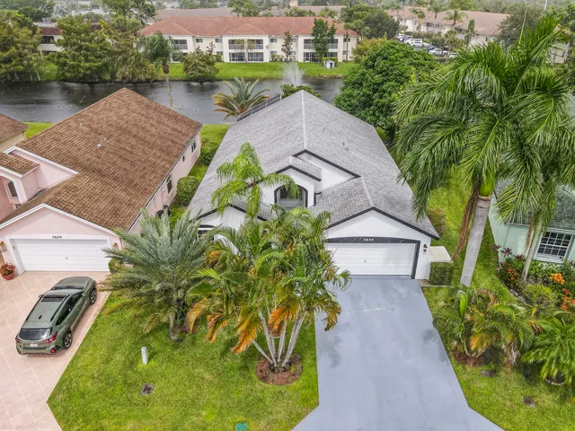 an aerial view of a house with swimming pool and garden