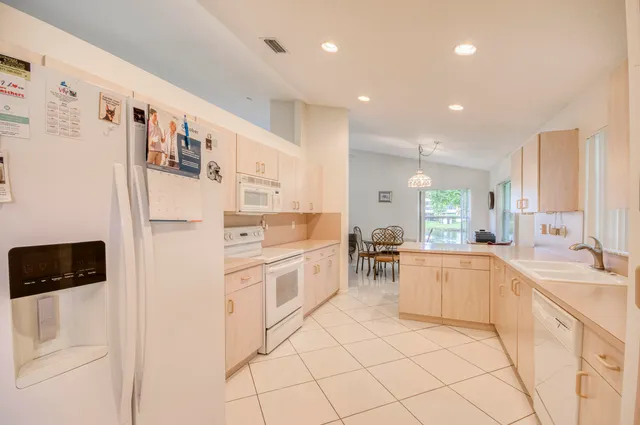 a kitchen with stainless steel appliances a refrigerator sink and white cabinets