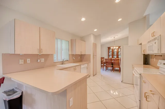 a kitchen with a sink a stove a refrigerator and white cabinets