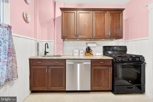 a kitchen with stainless steel appliances granite countertop a sink and a refrigerator
