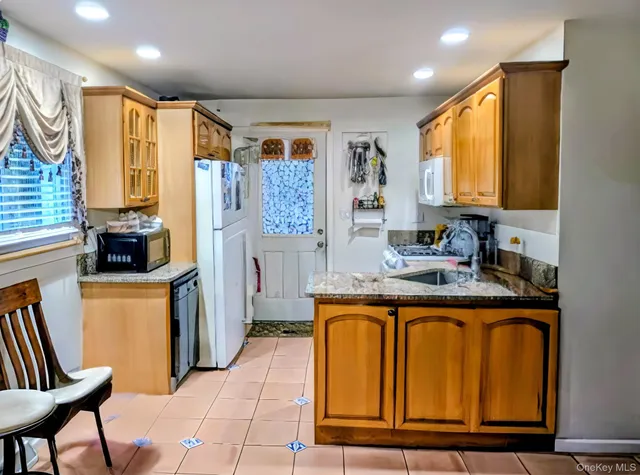 a kitchen with stainless steel appliances granite countertop a refrigerator and a stove