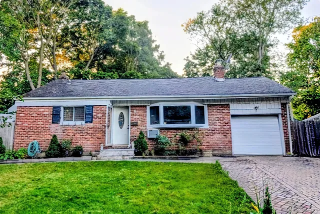 a front view of a house with a garden and plants