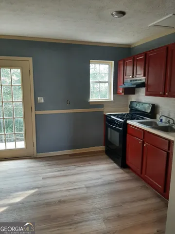 a kitchen with granite countertop wooden cabinets and a wooden floor