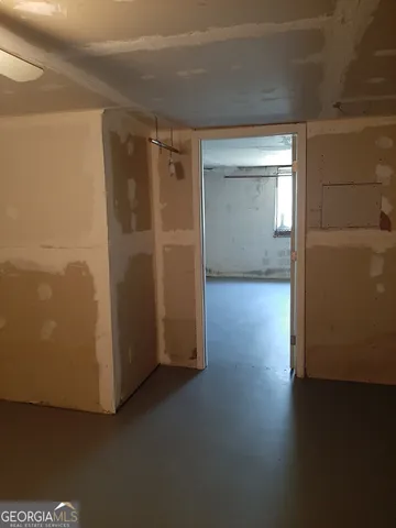 an empty room with wooden floor cabinet and windows