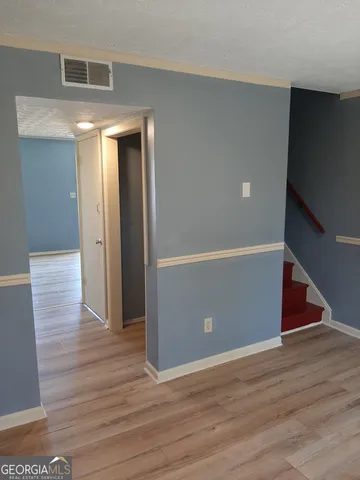a view of an empty room with wooden floor