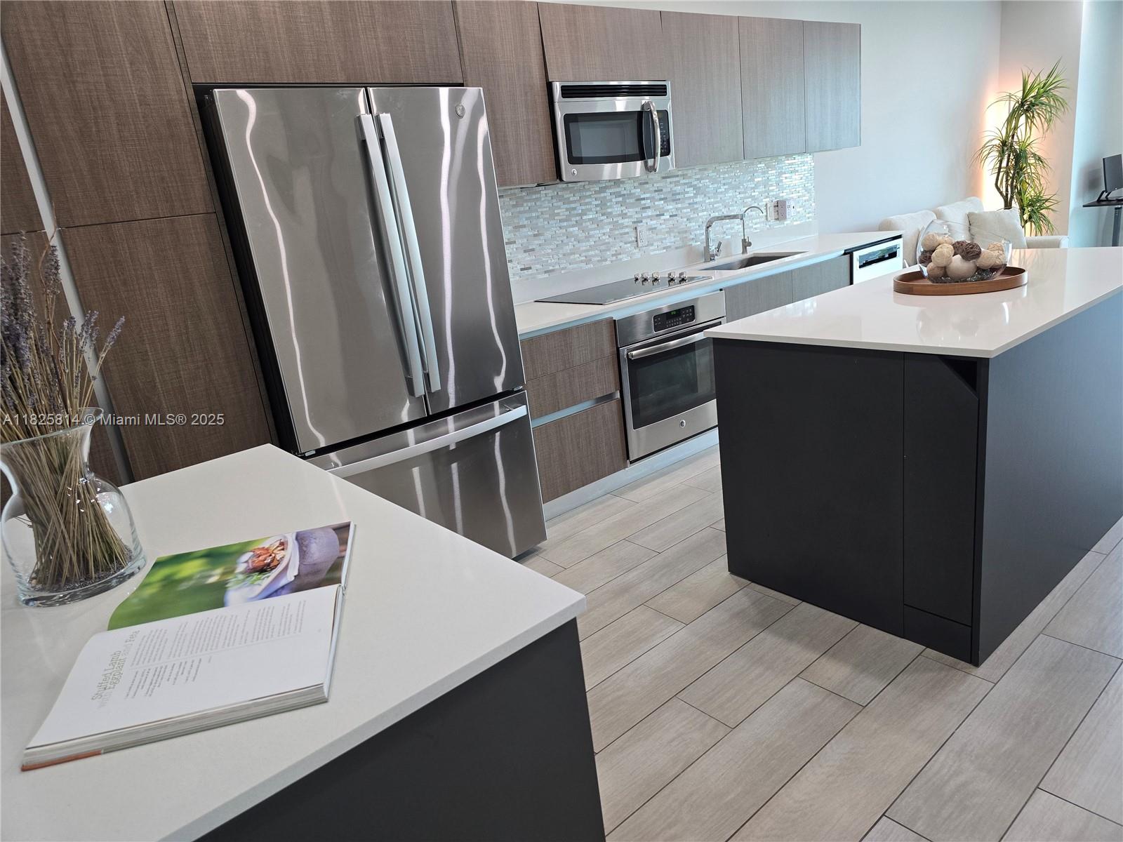 1600 Southwest 1st Avenue, Unit 809 Miami, FL 33129 - Photo 4 of 24 a kitchen with stainless steel appliances a sink stove and refrigerator