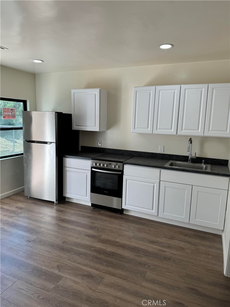 4764 Indian Hill Road Riverside, CA 92501 - Photo 5 of 8 a kitchen with granite countertop white cabinets and stainless steel appliances