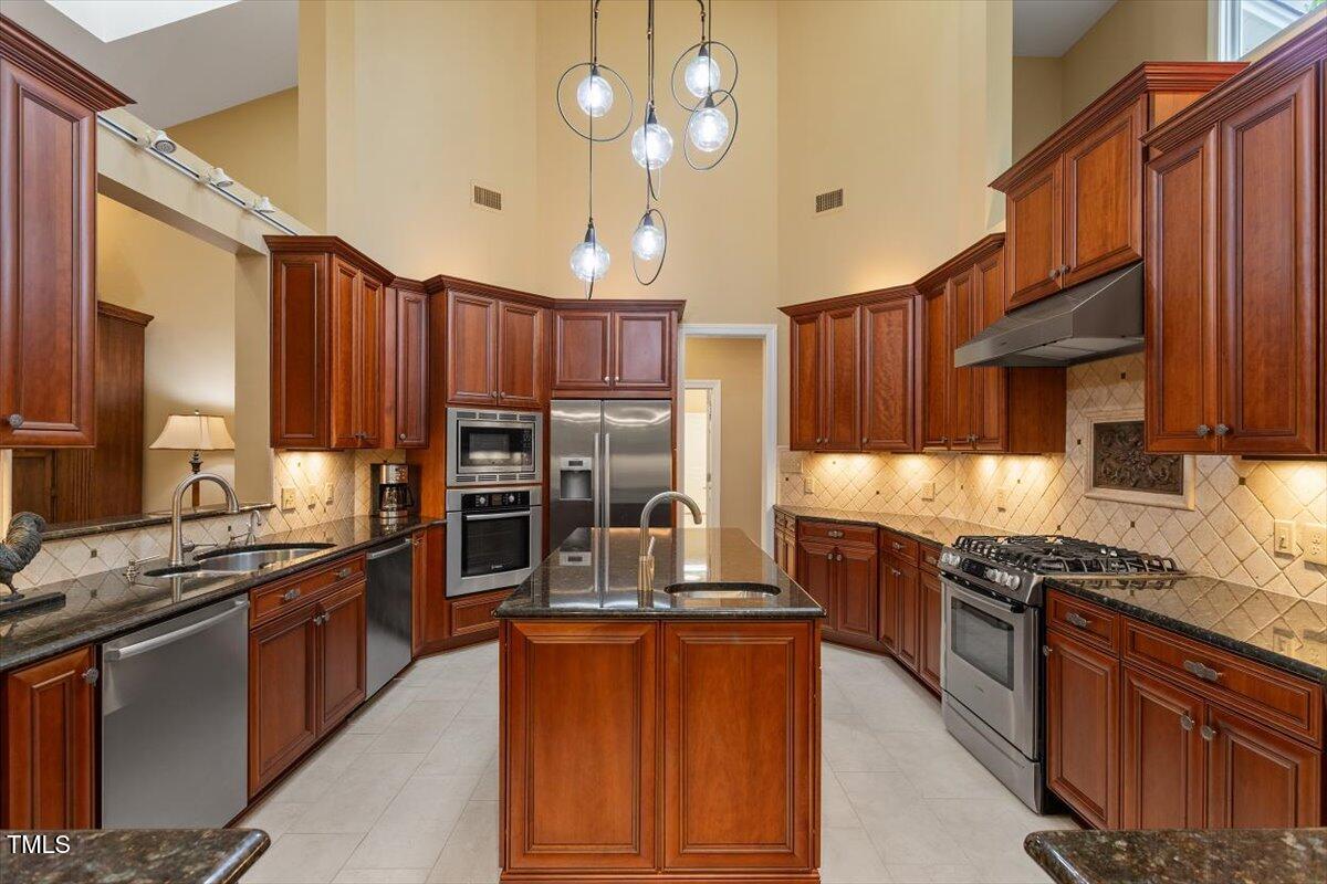 919 Woodham Pittsboro, NC 27312 - Photo 15 of 43 a kitchen with stainless steel appliances granite countertop a stove top oven a sink dishwasher a dining table and chairs