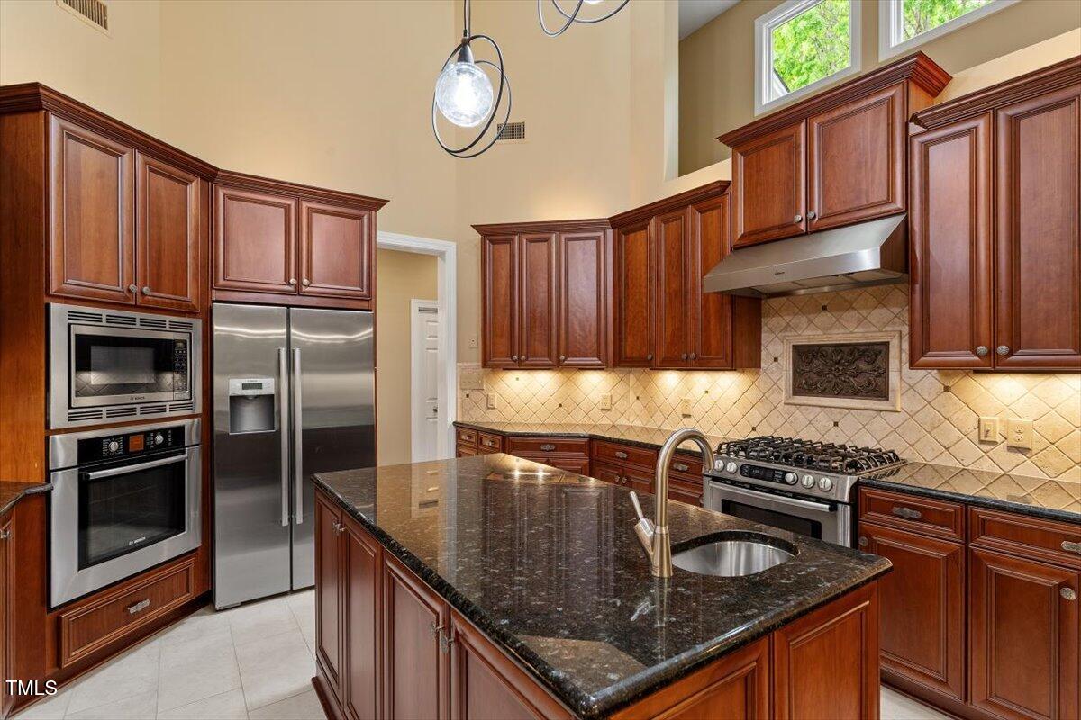919 Woodham Pittsboro, NC 27312 - Photo 16 of 43 a kitchen with granite countertop a stove cabinets and stainless steel appliances