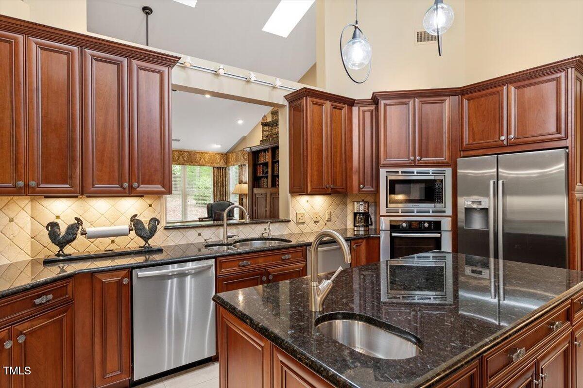 919 Woodham Pittsboro, NC 27312 - Photo 18 of 43 a kitchen with granite countertop a sink a counter space appliances and cabinets