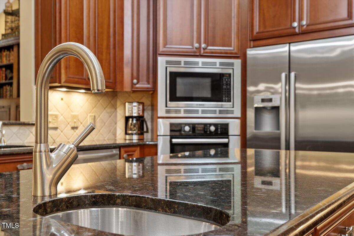 919 Woodham Pittsboro, NC 27312 - Photo 19 of 43 a kitchen with granite countertop a refrigerator and a stove
