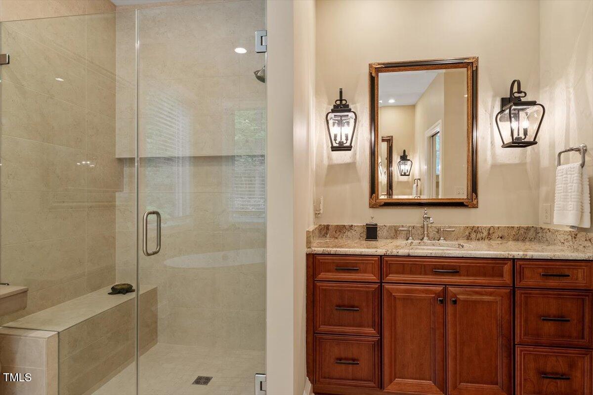 919 Woodham Pittsboro, NC 27312 - Photo 28 of 43 a bathroom with a granite countertop sink a mirror and shower